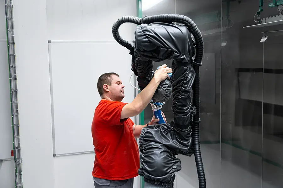Pracovník lakovny v robotické lakovací kabině