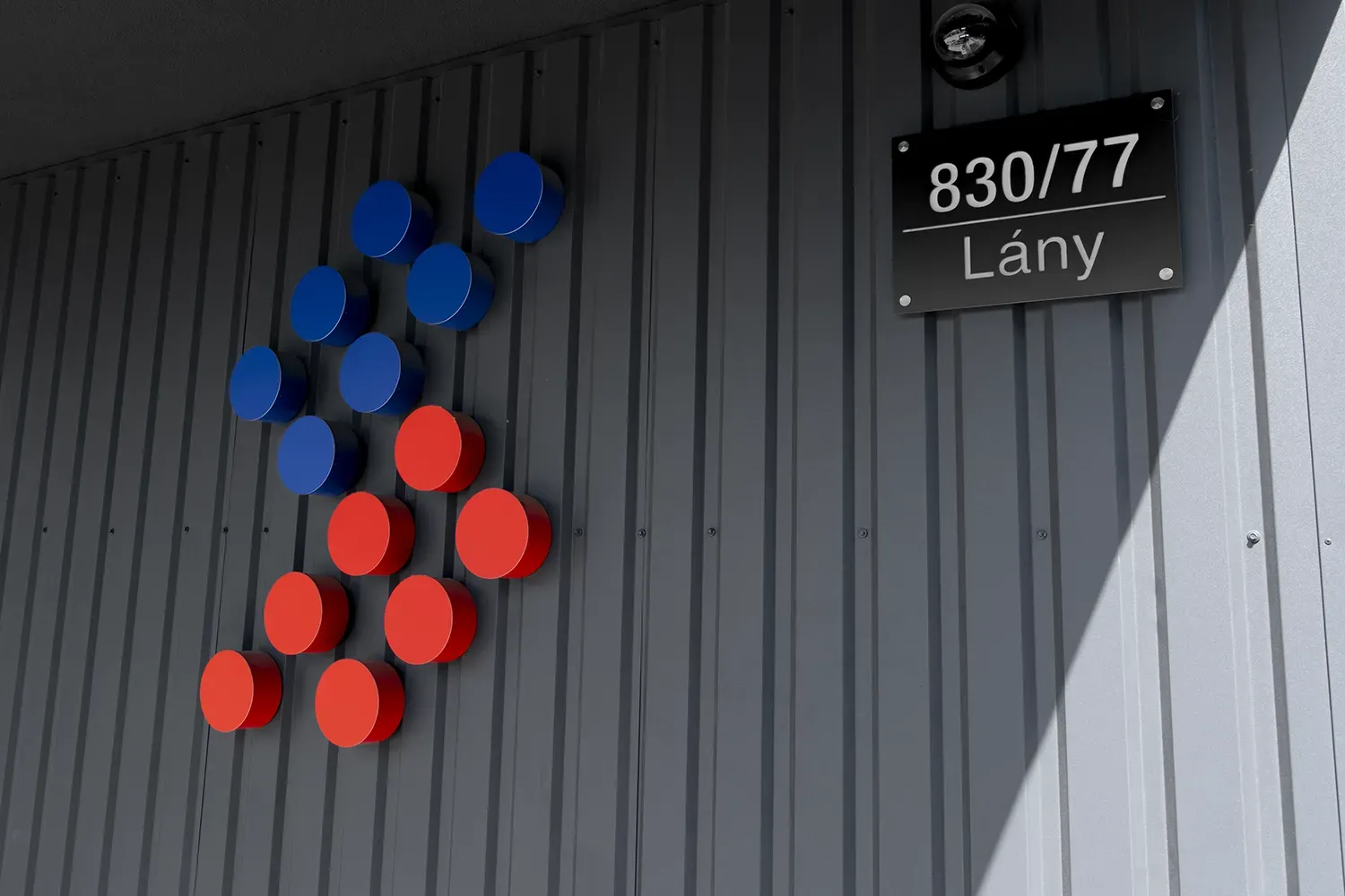 Logo SURFIN Technology připevněné na zdi s adresou domu