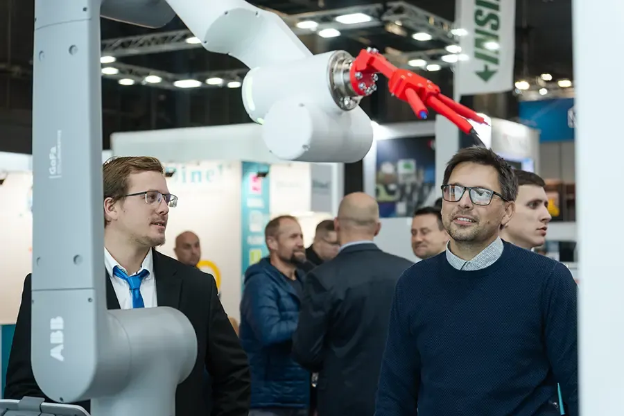 Muž sleduje robotickou paži na stánku společnosti SURFIN Technology na veletrhu MSV 2025