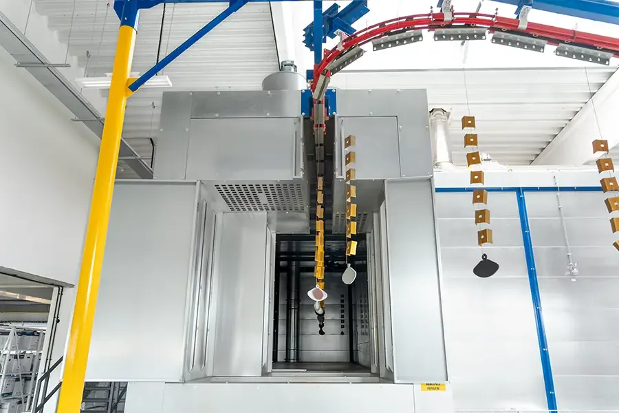 Kovové díly na dopravníku opouštějící sušicí pec