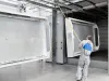 Worker pulling metal parts on conveyor