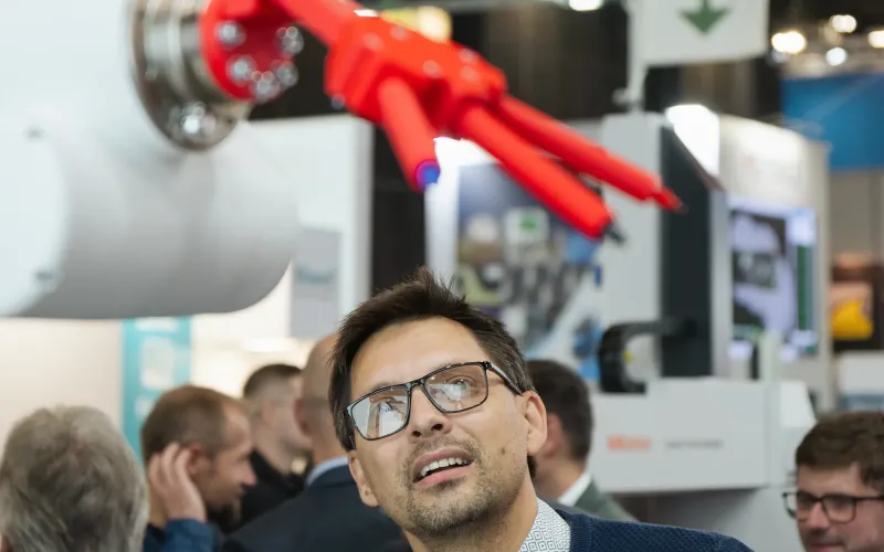 Návštěvník veletrhu pozoruje inovativní robotický exponát