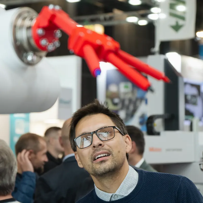 Návštěvník veletrhu pozoruje inovativní robotický exponát