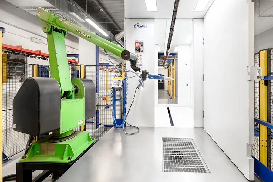 Robotic coating arm with coating booth in the background