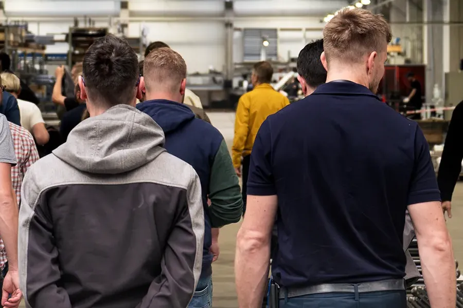 Muži chodící v industriální továrně