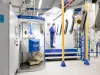 Worker manually coating metal parts