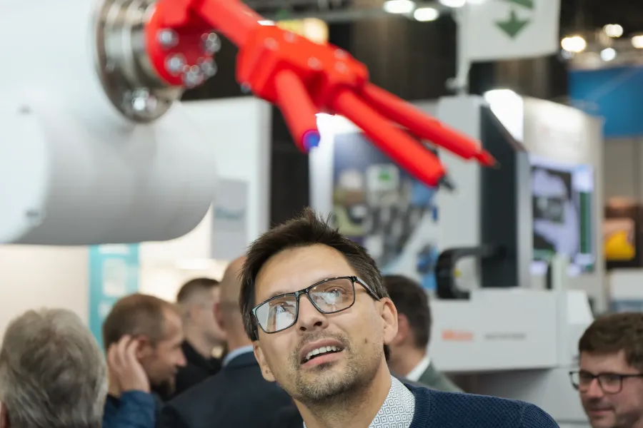 Návštěvník veletrhu pozoruje inovativní robotický exponát