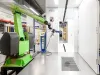 Robotic coating arm with coating booth in the background
